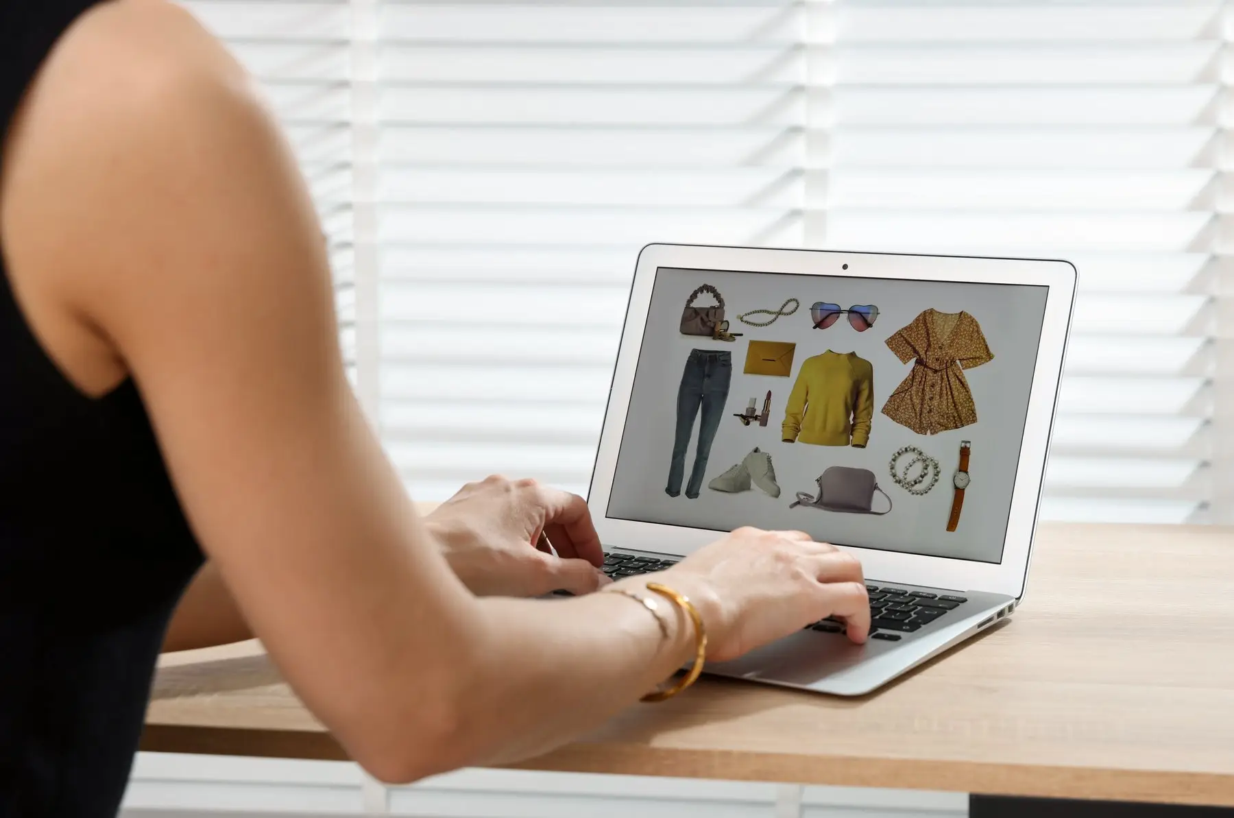 Une femme parcourt une boutique en ligne de vêtements et d’accessoires sur son ordinateur portable