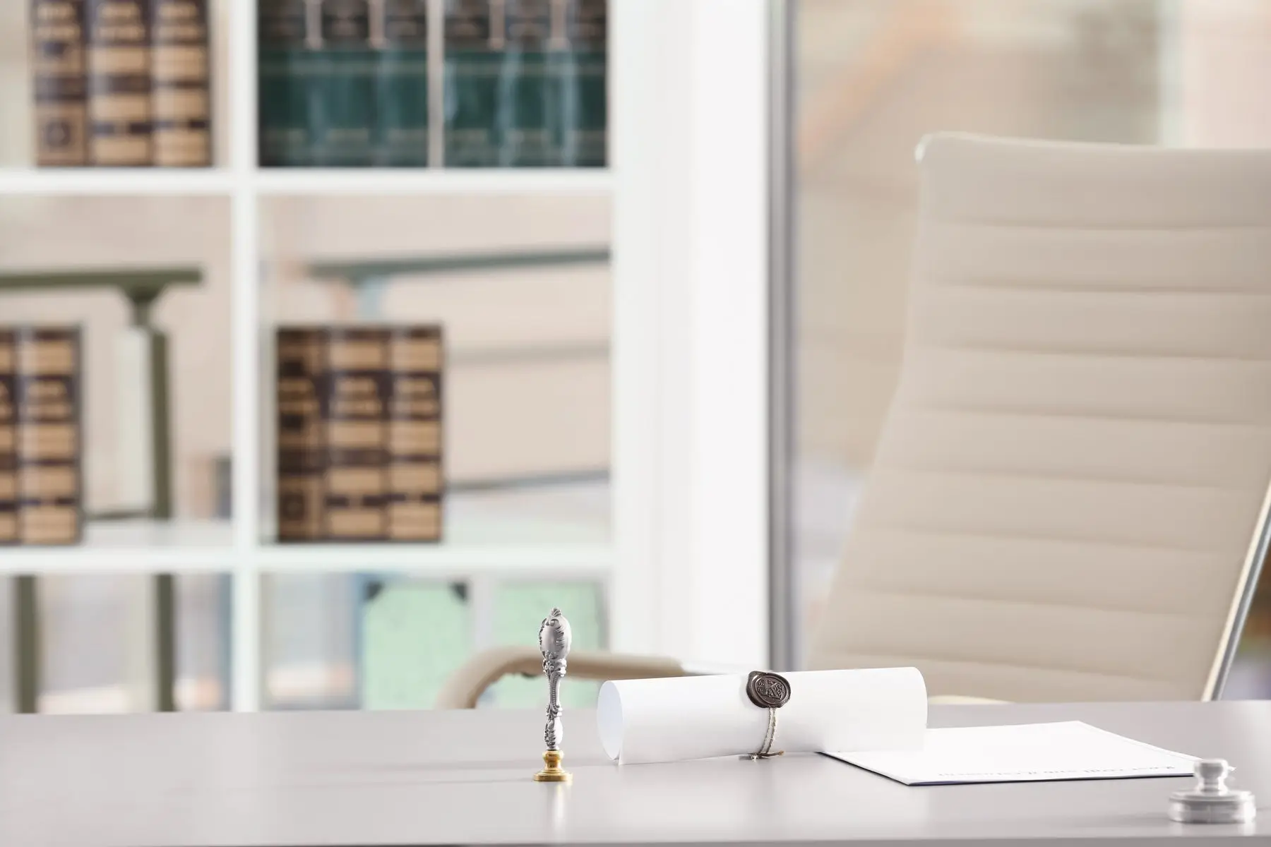 Un bureau clair avec un acte scellé à la cire et un sceau, devant une bibliothèque de livres reliés