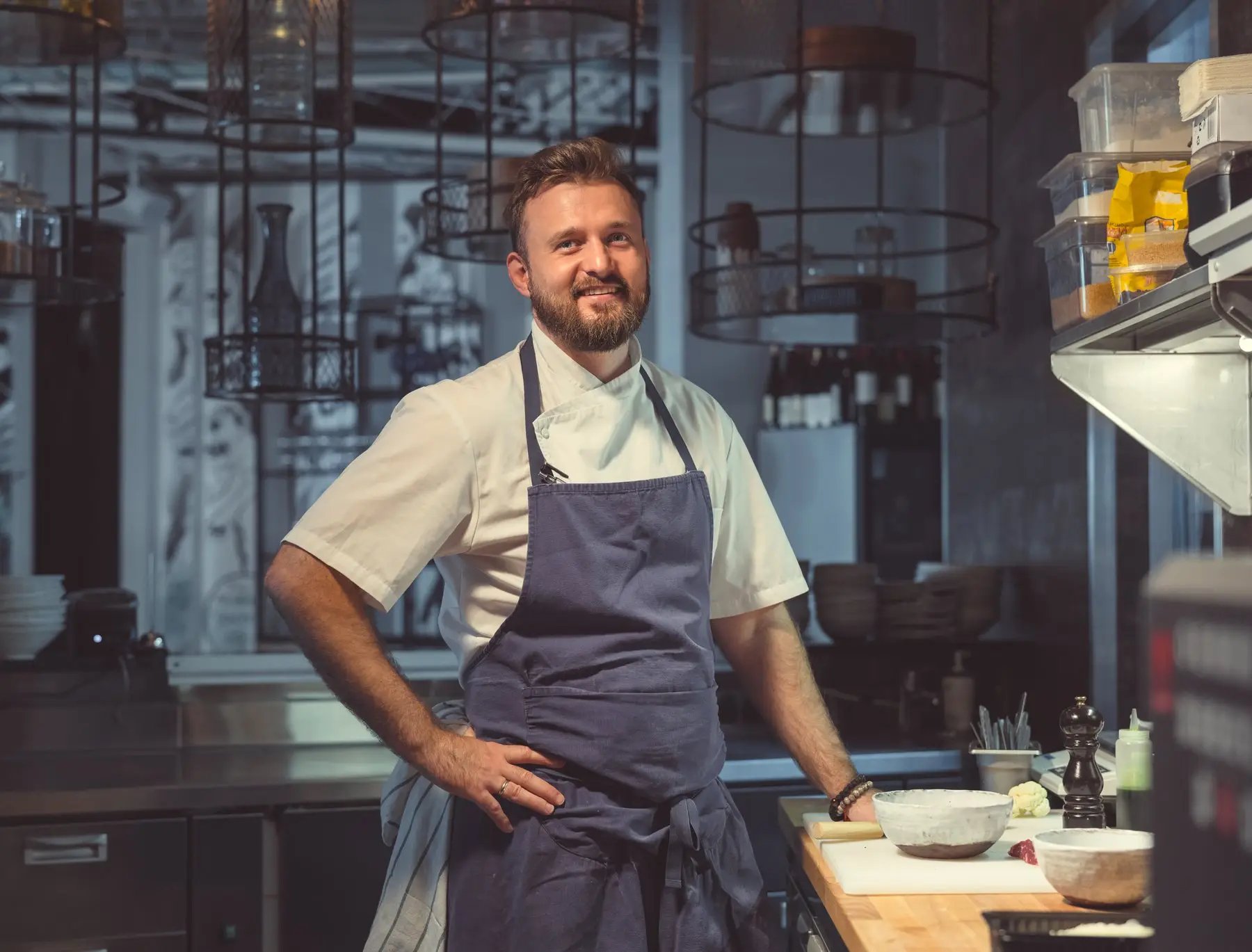 Un chef cuisinier souriant au travail dans la cuisine de son restaurant