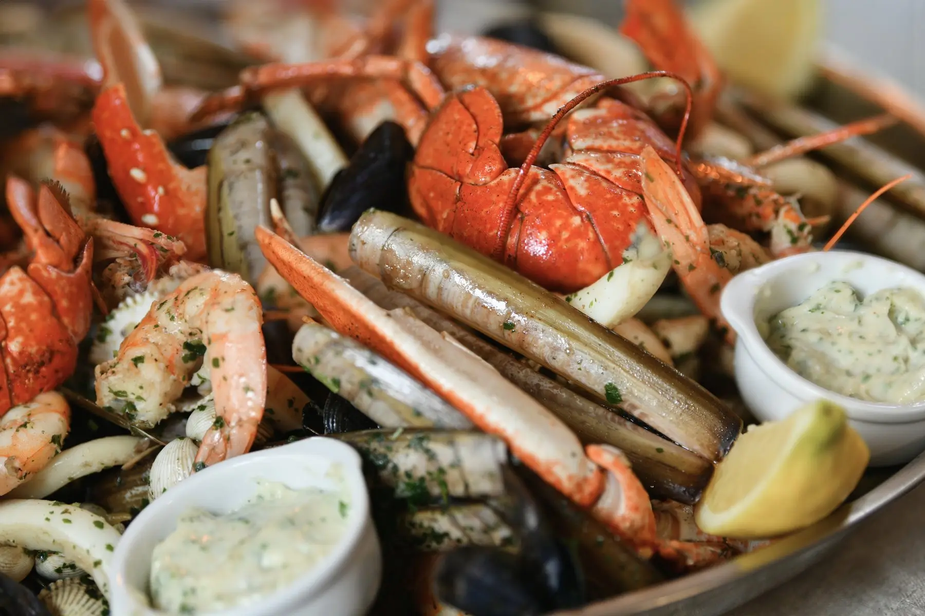 Plateau de fruits de mer : homard, langoustines, couteaux, crevettes et coquillages, avec du citron