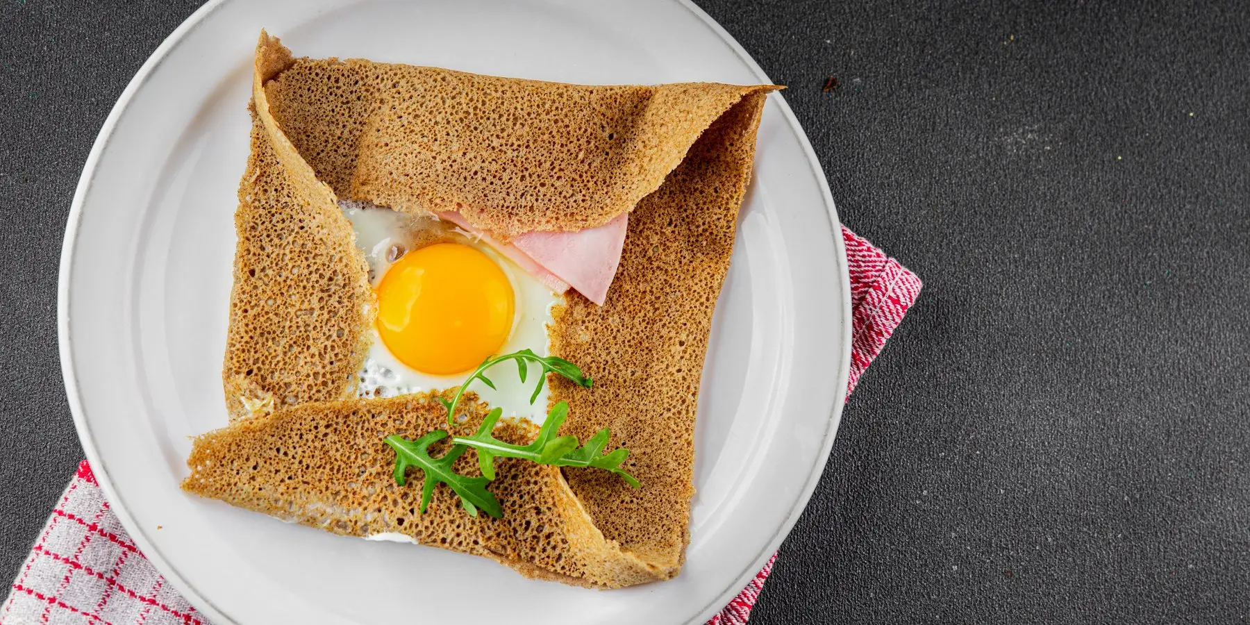 Une galette complète œuf-jambon servie dans une assiette