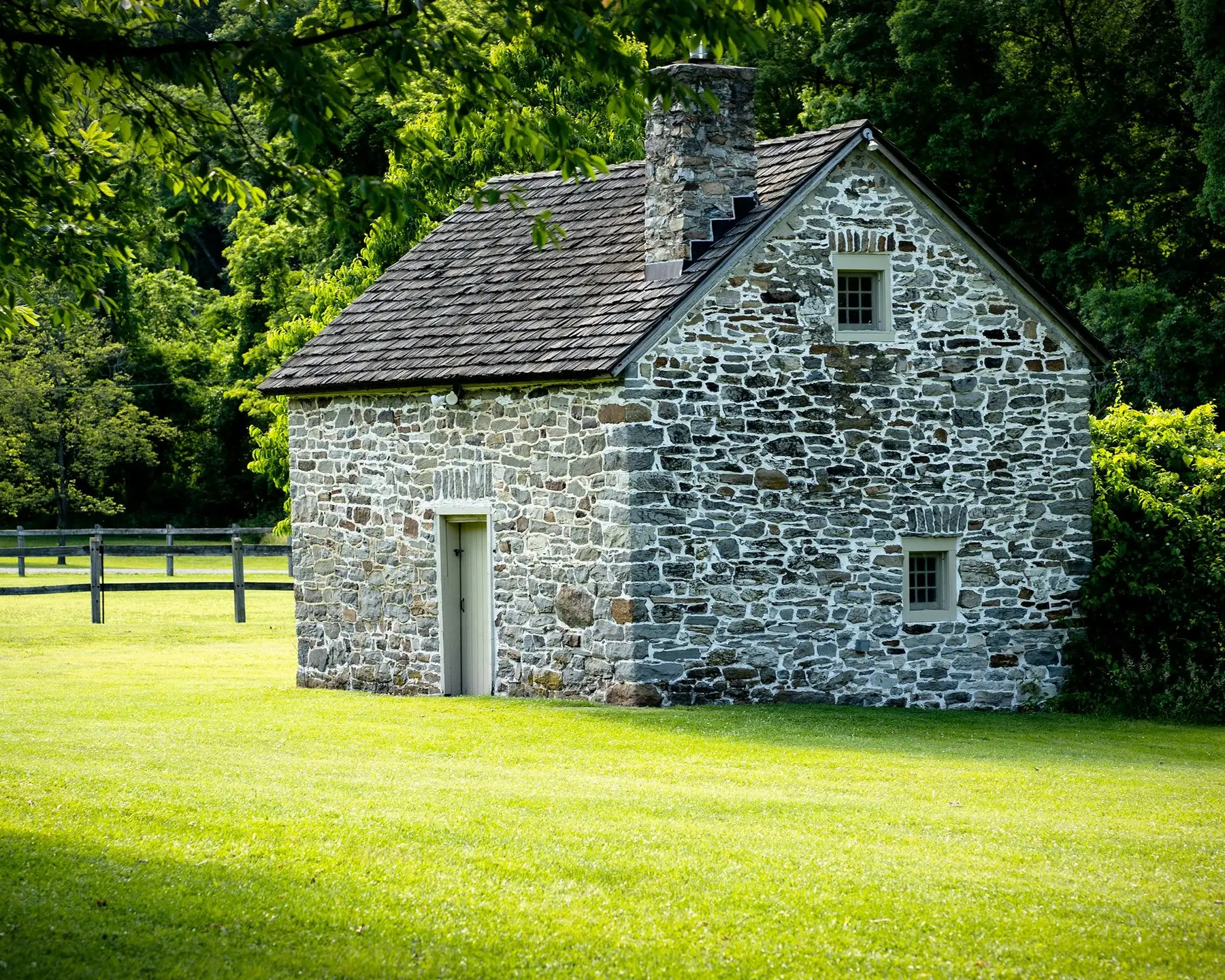 Une petite maison de pierre au milieu d’un pré