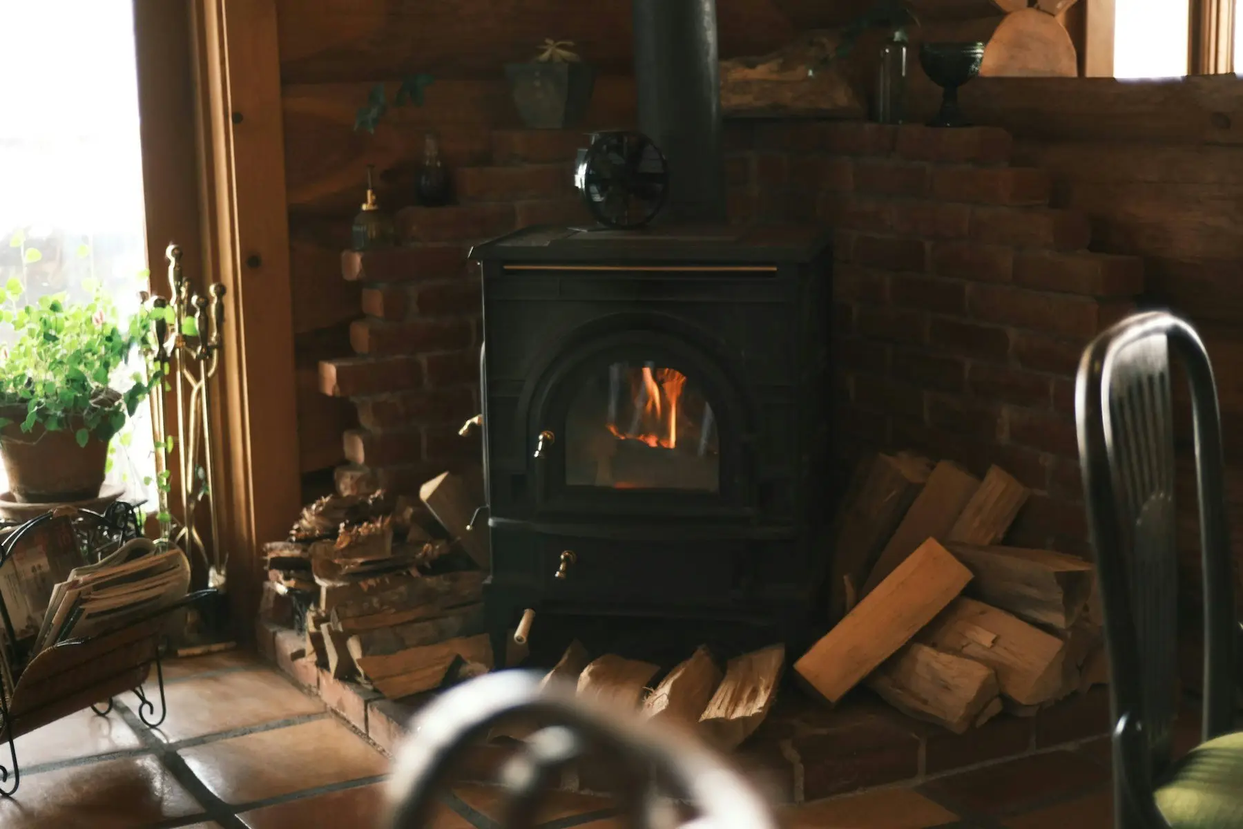 Le salon d’un gîte avec un poêle à bois et des fauteuils
